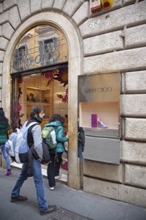Italy, Lazio, Rome, Via del Condotti Tourists looking at shoe display in the Jimmy Choo shop.