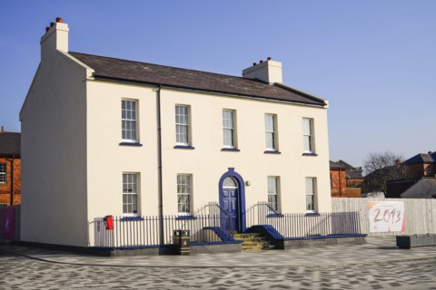 Ireland, North, Derry, Former Ebrington Barracks building with blue doorway and small Derry 2013