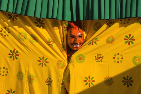 Bhutan, Thimpu Dzong, Atsara, or comedian peering out from behind a curtain at a masked dance