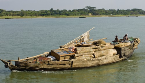 Bangladesh, Industry, Transport, Boat heavily laden with cargo of timber and furniture on river.