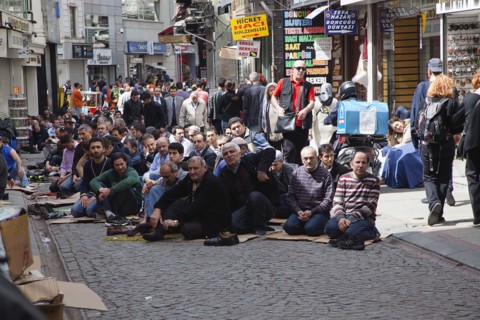 Turkey, Istanbul, Fatih, Sultanahmet, Men sat in street in readiness for midday prayers. 
Photo