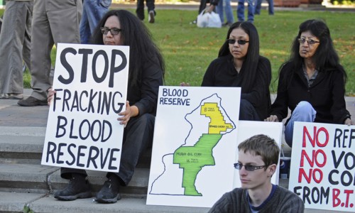 Canada, Alberta, Lethbridge, Three Blood Tribe members holding protest signs at anti-fracking