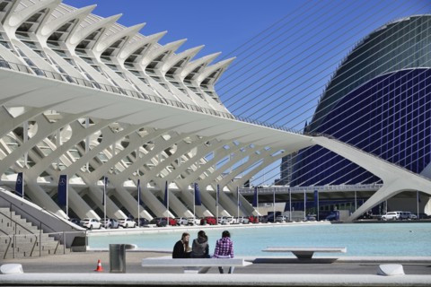 Spain, Valencia Province, Valencia, La Ciudad de las Artes y las Ciencias  City of Arts and Sciences  Principe Felipe Science Museum  General view of the building with girls on seat in the forground a...