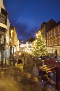 England, Hampshire, Winchester, High street decorated with Christmas tree and decorations, seen from the Buttercross.