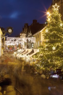 England, Hampshire, Winchester, High street decorated with Christmas tree and decorations, seen from the Buttercross.