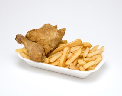 Food, Cooked, Poultry, Battered chicken breast fillet and drumstick with potato chips in a polystyrene foam tray on a white background.