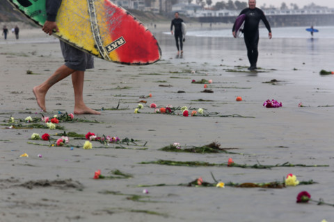 Dozens of surfers and family members of Larry Gordon paddled out Monday at Tourmaline Beach.